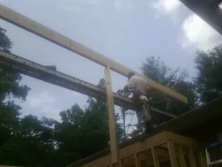 Carpenter setting a ridge beam over a new addition frame — Ice Dam Removal by Roofing Brothers in East Waterford