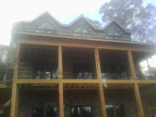 Dormers and porch framing on a large log home under construction — Roof Coating work by our crew in East Waterford