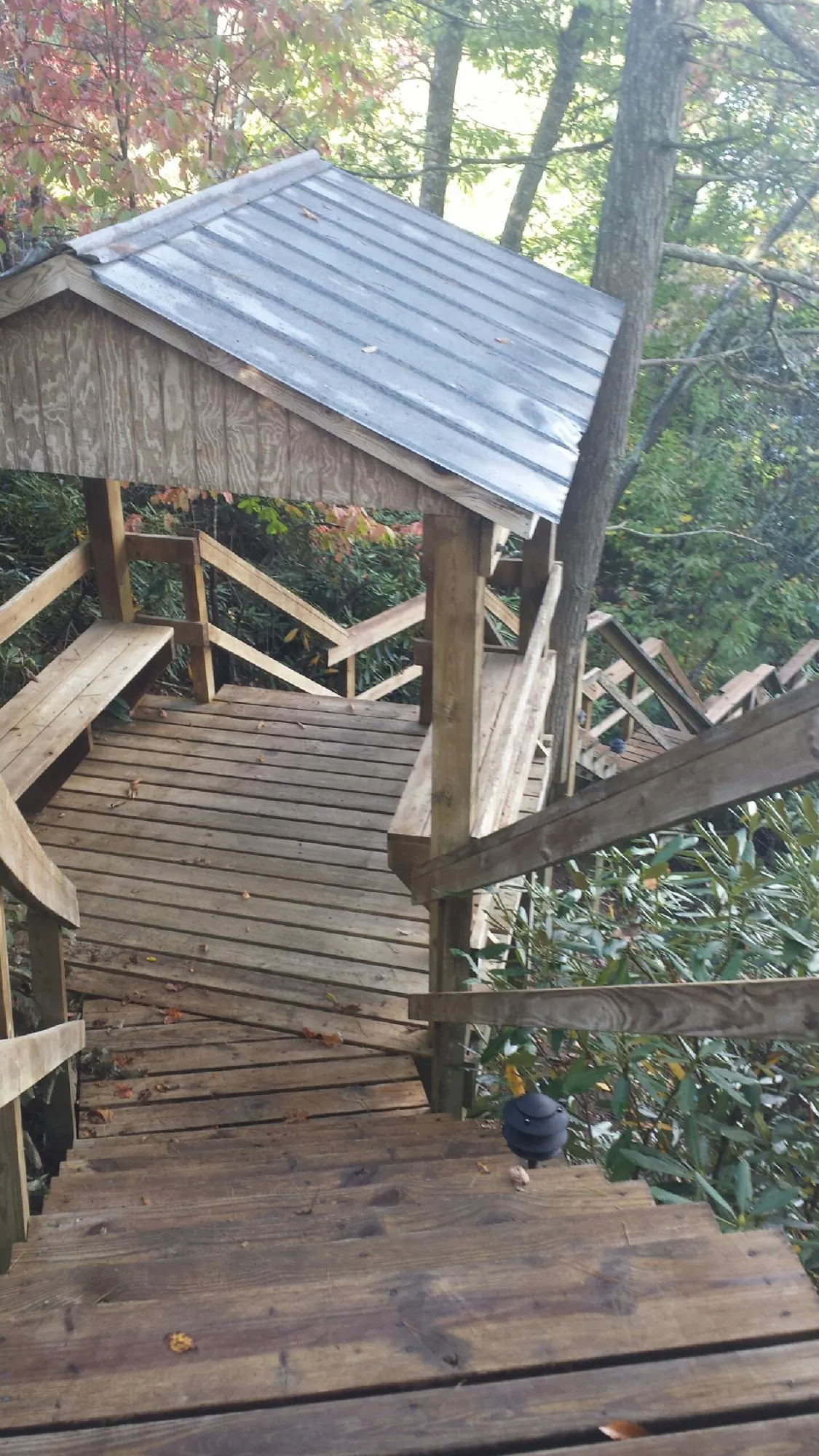 Metal roofed shelter over wooden steps on a wooded walkway — Skylight Repair & Installation work by our crew in East Waterford